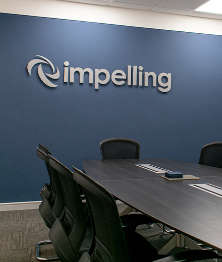 The Impelling board room with logo on the wall