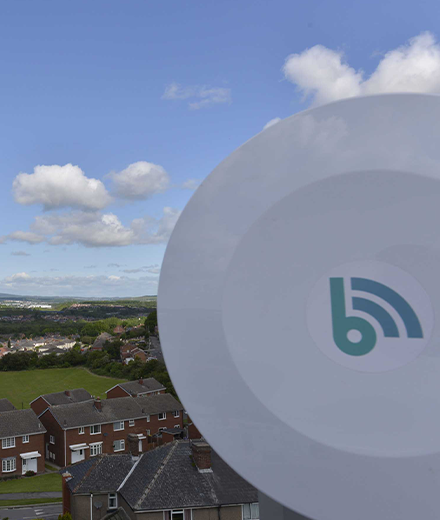 A Bliss Internet wireless internet device on a mast overlooking a village